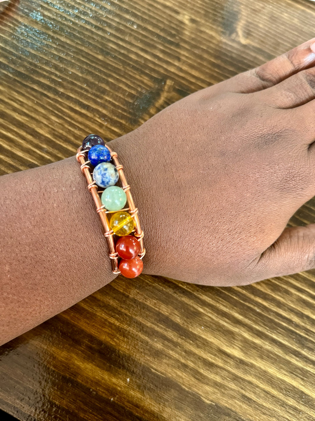 Copper Vibrations handcrafted chakra bracelet with colorful gemstone beads wrapped in polished copper wire on a wrist