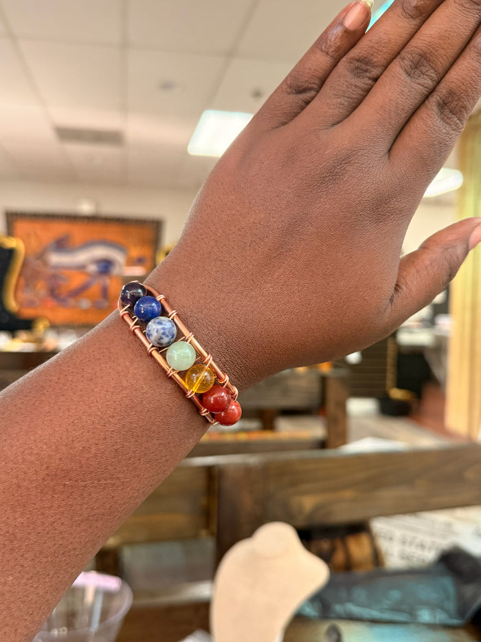 Copper Vibrations handcrafted chakra bracelet with colorful gemstone beads wrapped in polished copper wire on a wrist
